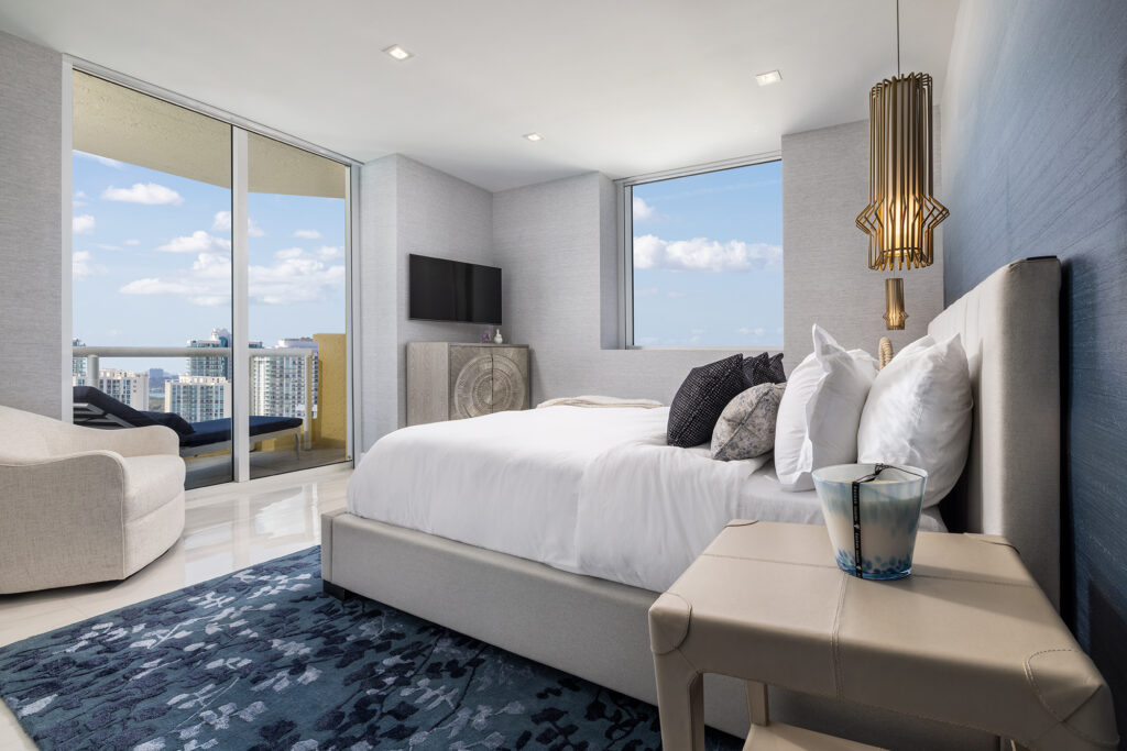 Luxury high-rise biophilic bedroom in Miami by Sarah Z Designs featuring panoramic views, natural daylight, and calming blue textures