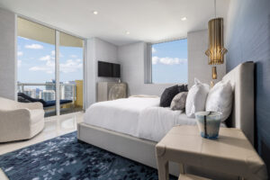 Luxury high-rise biophilic bedroom in Miami by Sarah Z Designs featuring panoramic views, natural daylight, and calming blue textures