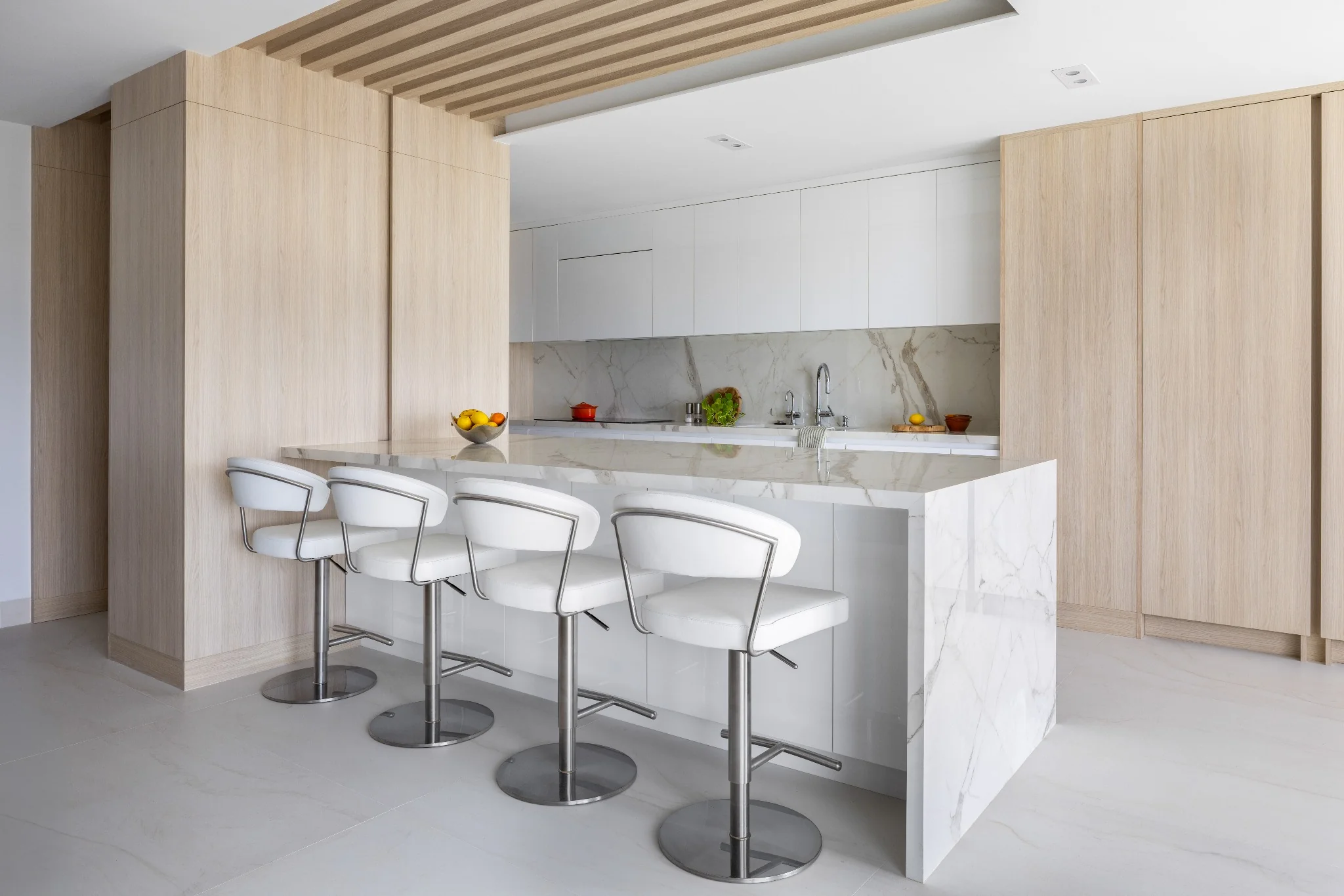 High-rise penthouse kitchen by Sarah Z Designs featuring natural millwork, warm architectural light and refined materials that embody biophilic living in Miami.
