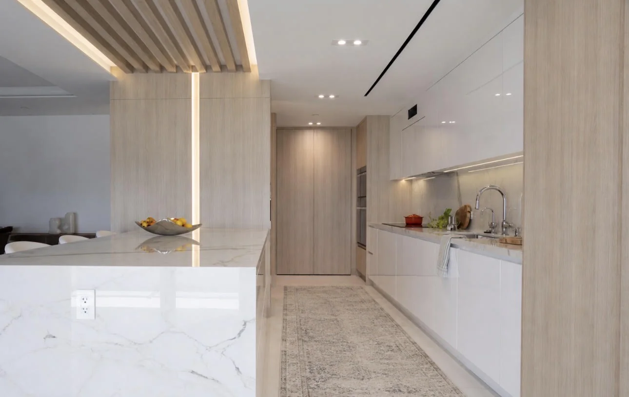 Miami condo kitchen by Sarah Z Designs where integrated circadian lighting and warm timber millwork soften the clean geometry of the room, a hallmark of biophilic interior design.