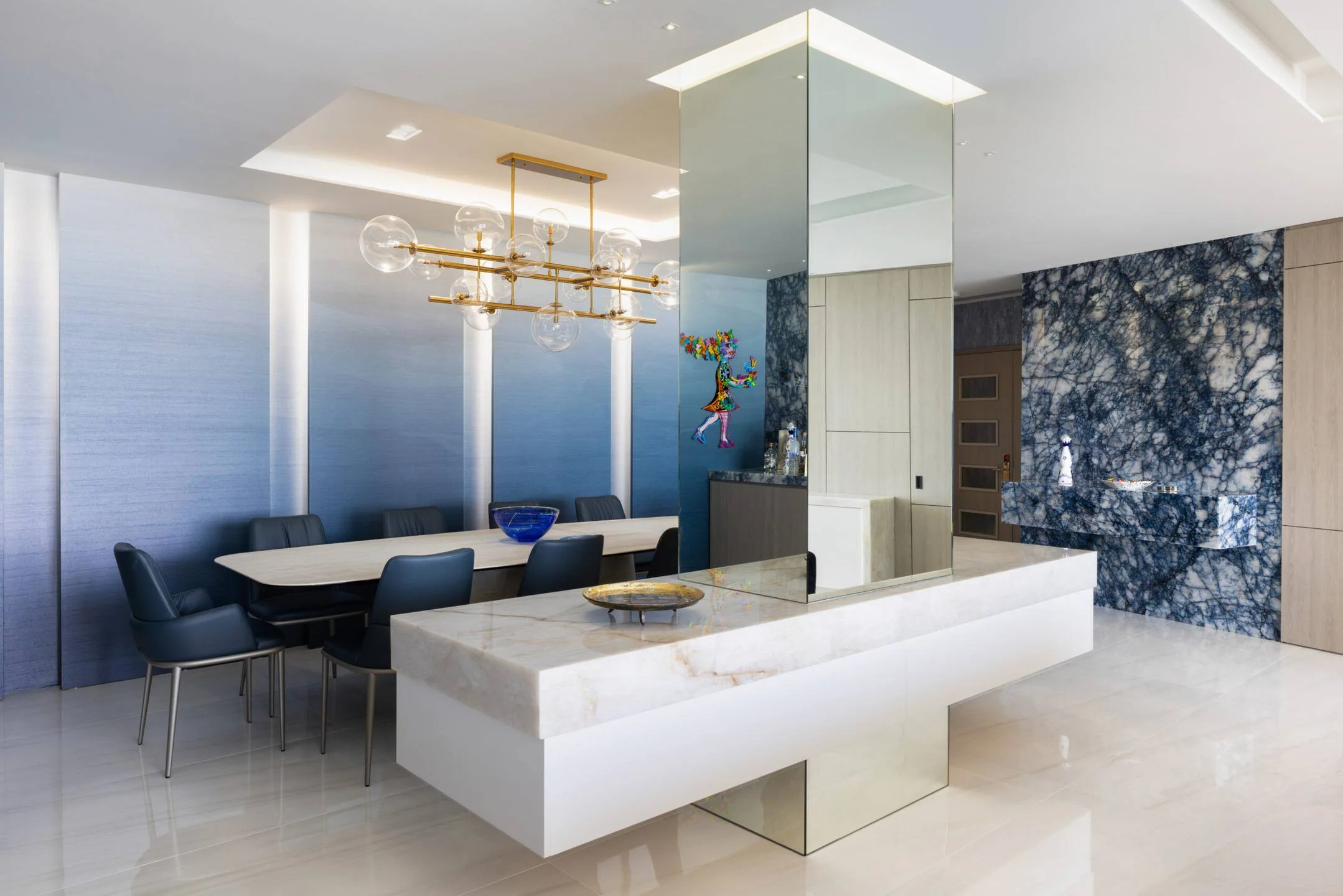 Natural stone, mirror, and warm wood in dialogue dissolve boundaries in this Organic Modern Miami interior.