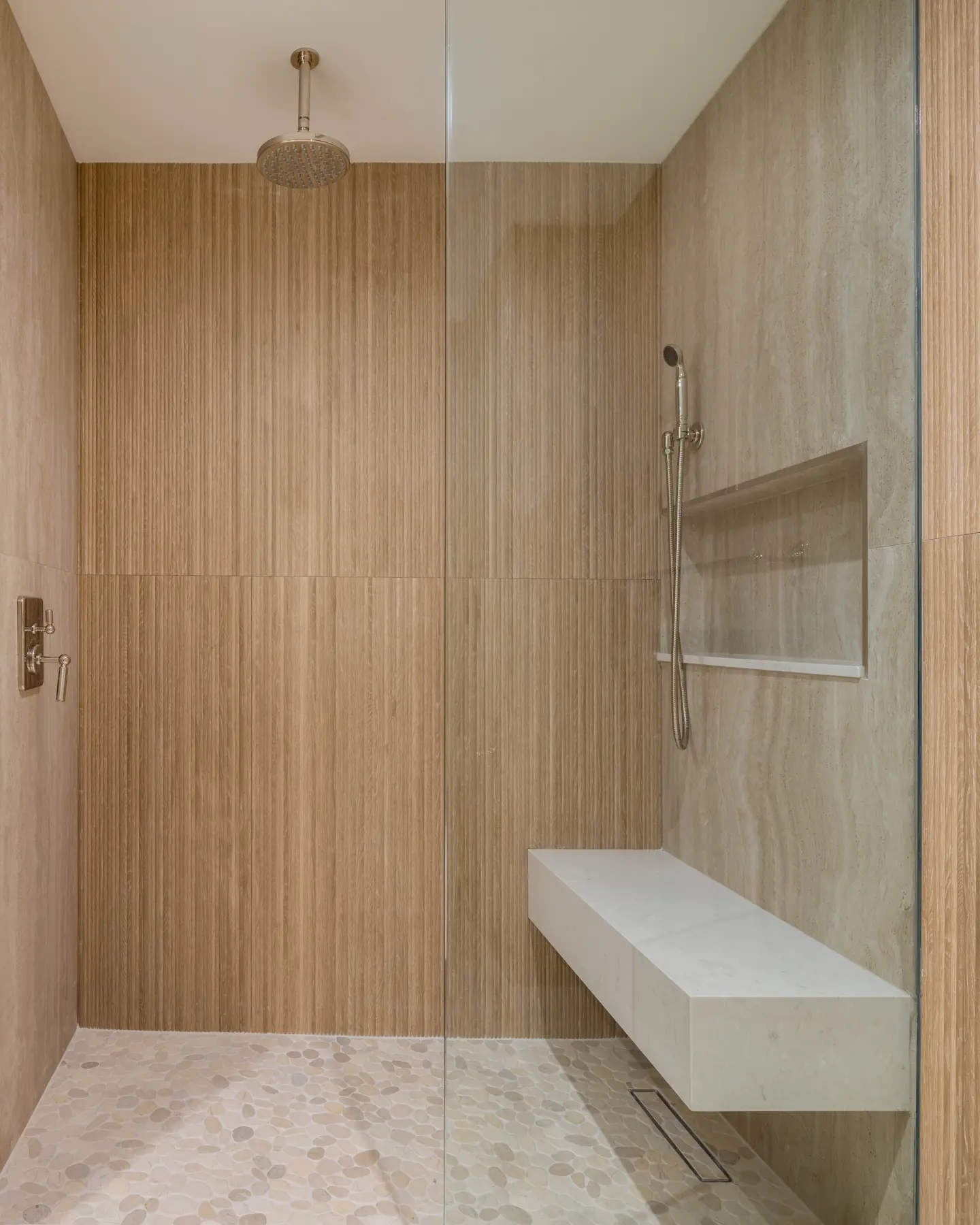 Slatted white oak and honed travertine: raw grain meets quiet stone in this Fall 2026 spa-inspired Coral Gables shower.