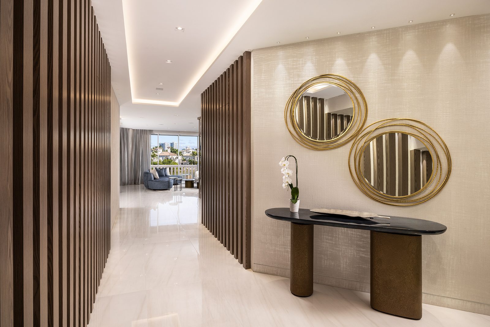 Slatted wood screens frame the gallery, revealing the living room in slices before it opens fully.